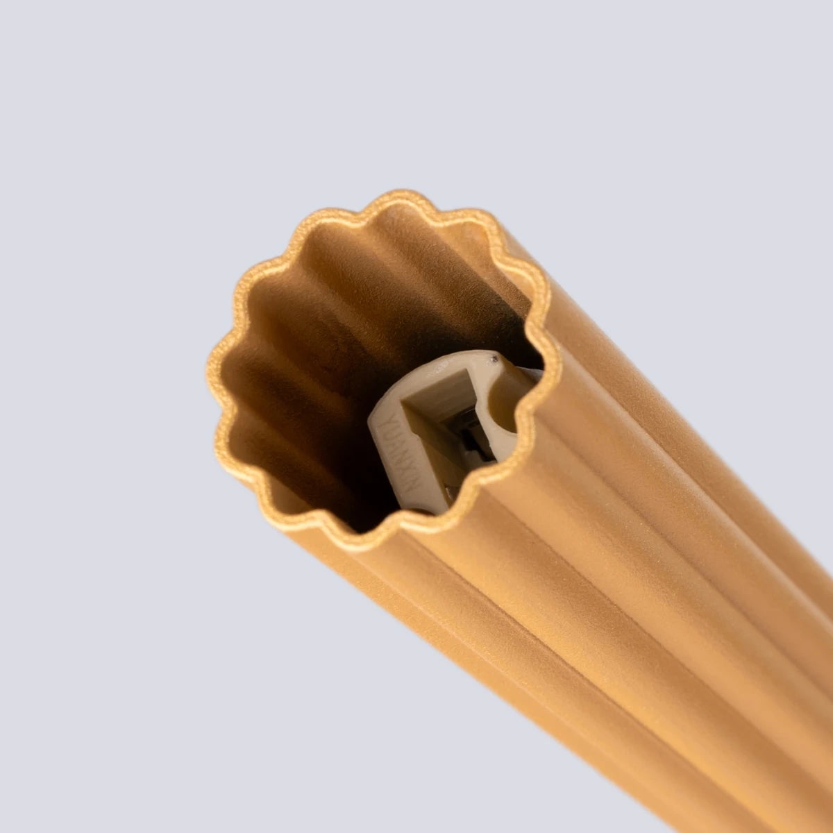 Makroaufnahme der Pendelleuchte CORA 1 in Gold – detailreiche Nahaufnahme der gerillten Struktur mit sichtbarer LED-Fassung.