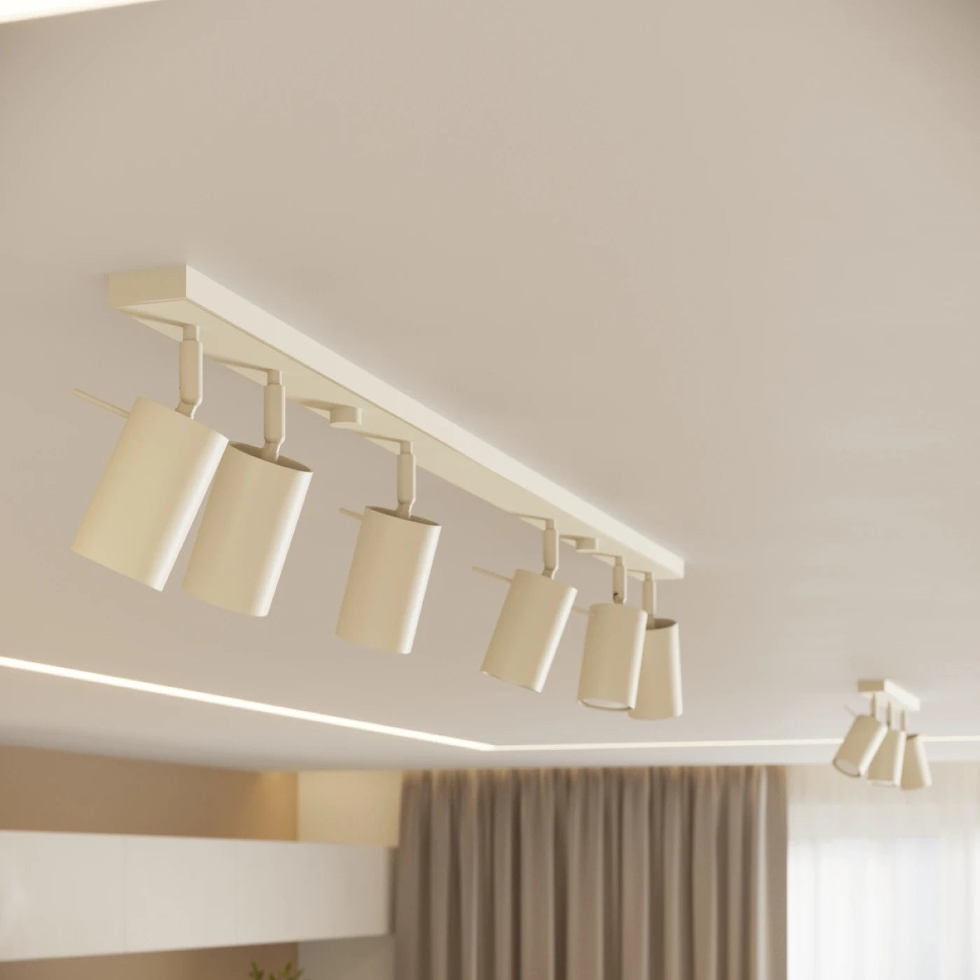 Moderner Deckenbereich mit sechs zylindrischen Deckenspots auf cremefarbenem Schienensystem und linearer LED-Streifenbeleuchtung an der Deckenkante