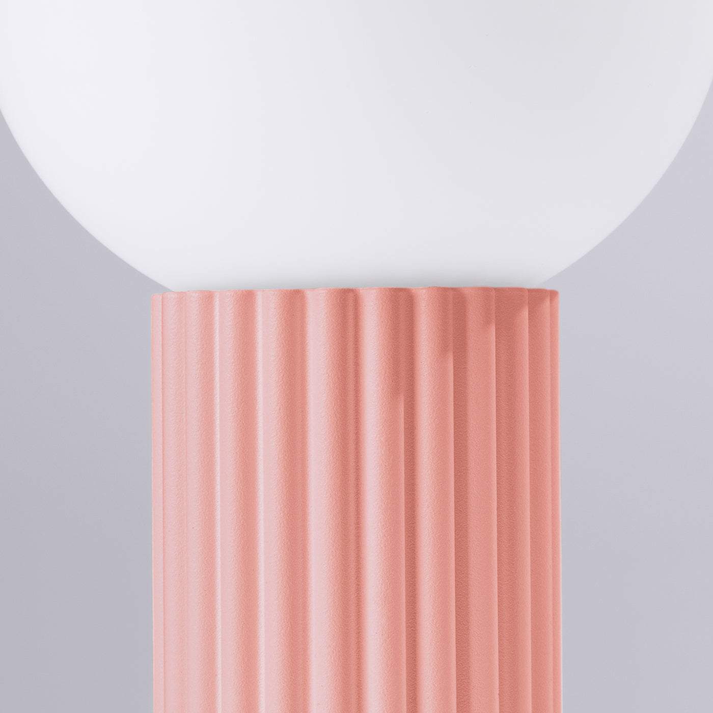 Detailaufnahme der HALO-Tischlampe in Apricot mit gerilltem Aluminiumfuß und matter Glaskugel.