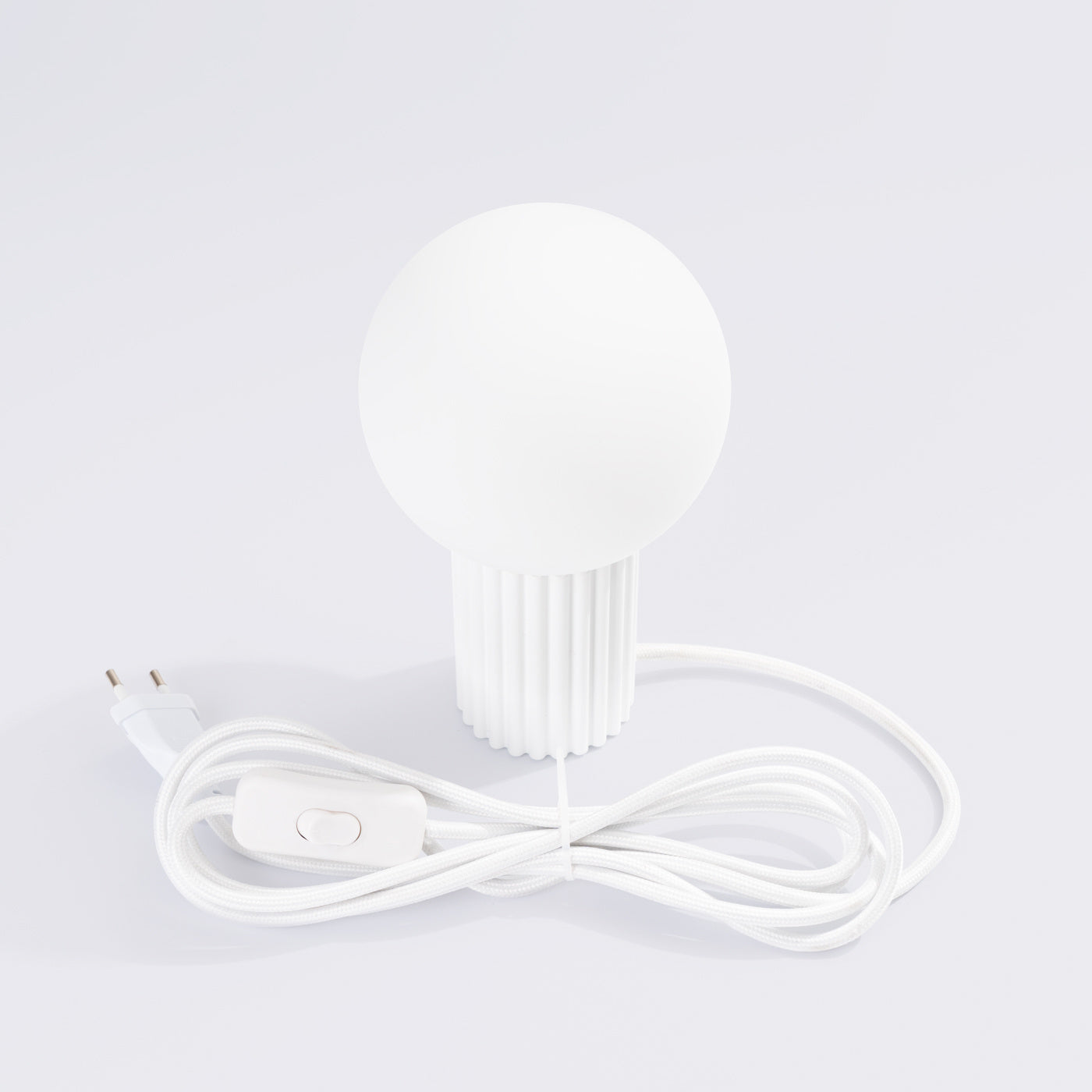 Weiße HALO-Tischlampe mit schwarzem Textilkabel und Schalter, eleganter Kontrast mit Milchglaskugel.