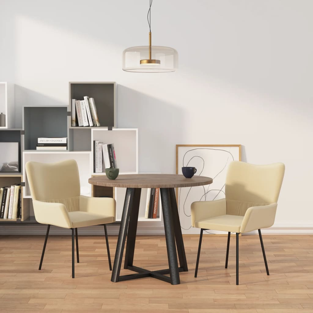 Runder Esstisch mit Holzplatte und schwarzen Metallbeinen, umgeben von zwei beigen Polsterstühlen in modernem Essbereich.