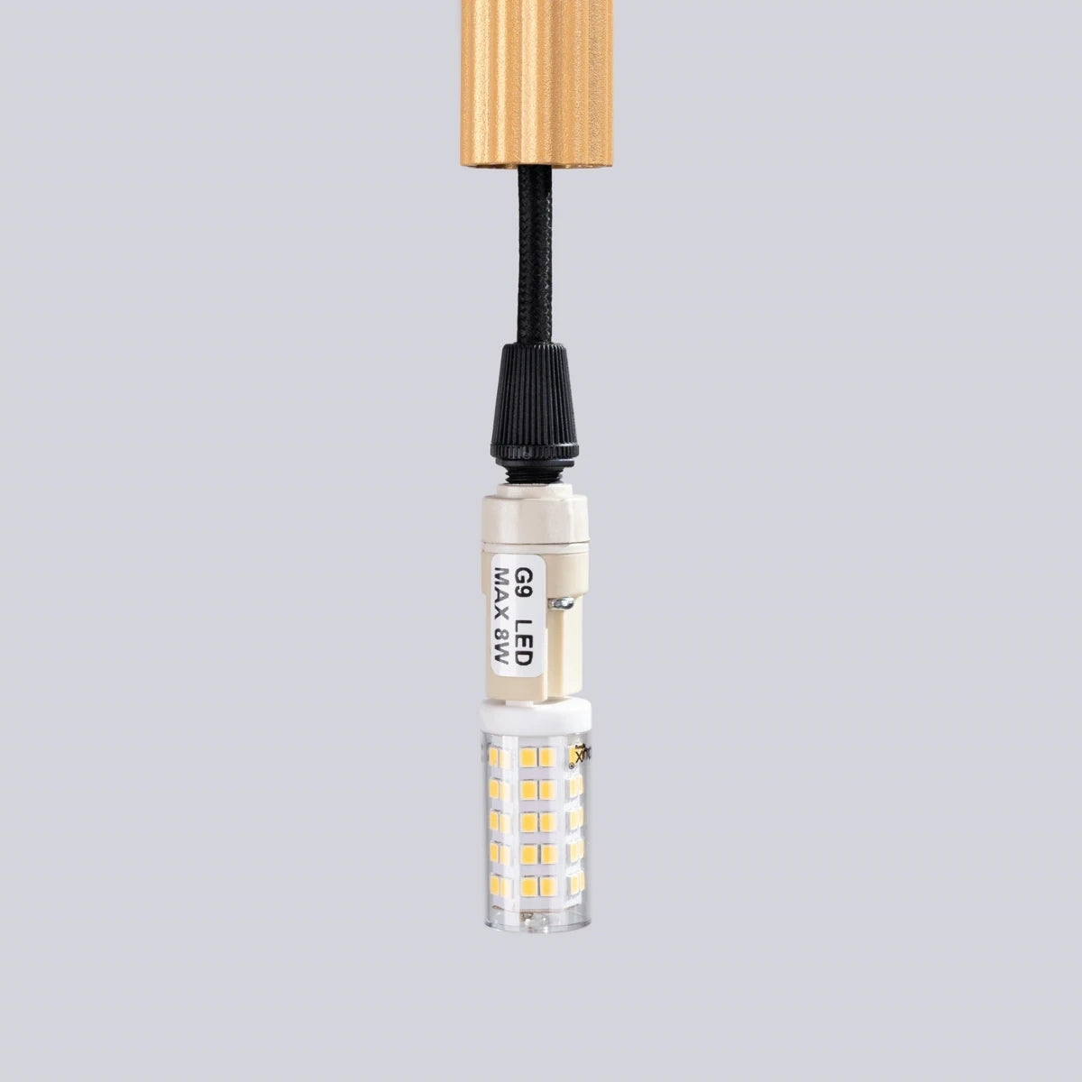 Pendelleuchte CORA 1 in Gold – Nahaufnahme der G9-LED-Fassung mit Leuchtmittel, schwarze Kabelführung und Aluminiumgehäuse.