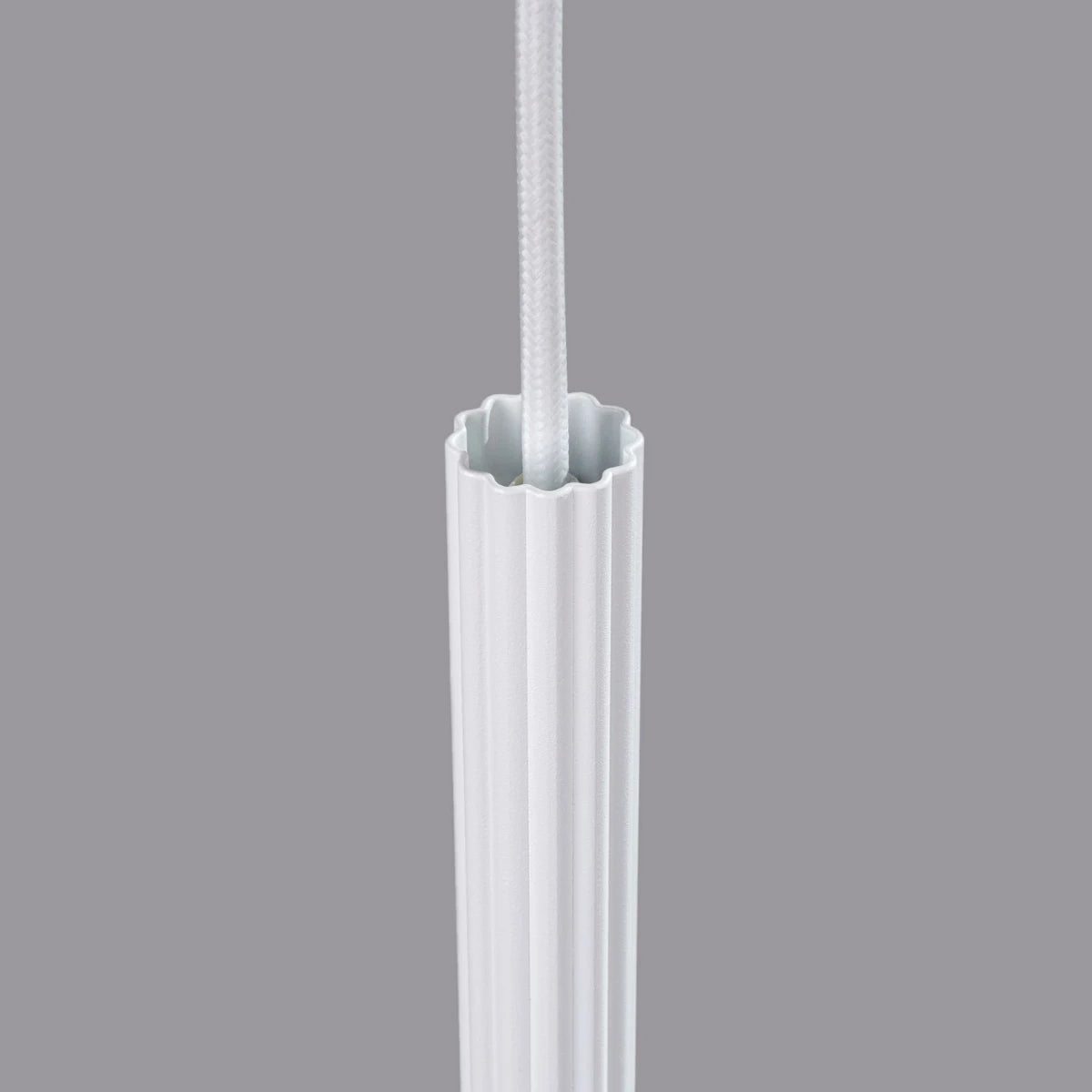 Detail der Pendelleuchte CORA 1 in Weiß – obere Lampenfassung mit feiner Rillenstruktur und textilummanteltem Kabel in modernem Design.