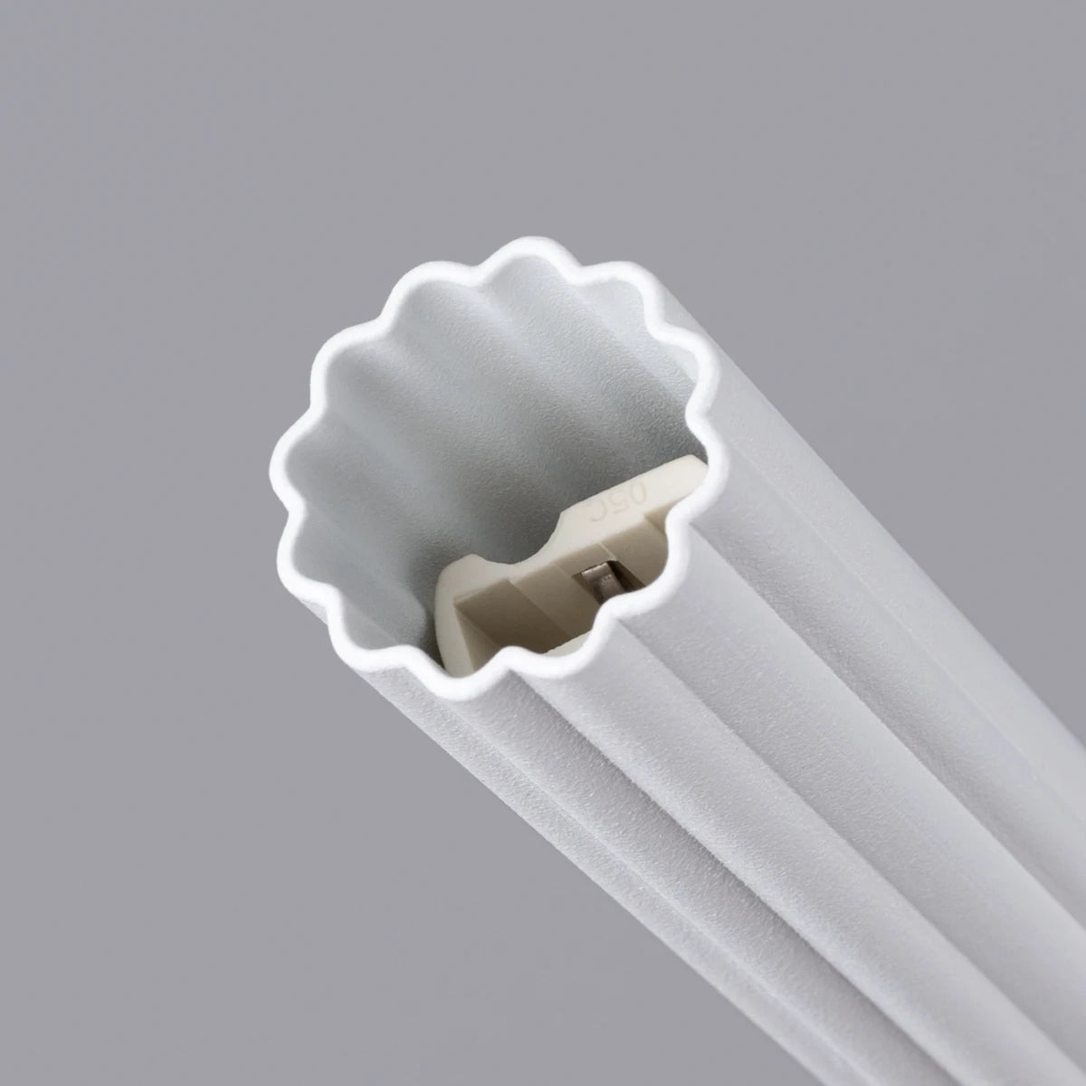 Makroaufnahme der Pendelleuchte CORA 1 in Weiß – präzise gefertigte Rillenstruktur aus Aluminium mit integrierter LED-Fassung.