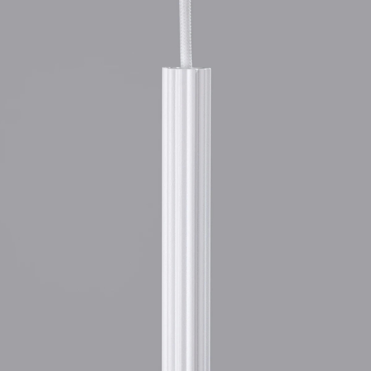 Detailansicht der Pendelleuchte CORA 1 in Weiß – fein gerilltes Aluminiumgehäuse mit textilummanteltem Kabel in modernem Design.