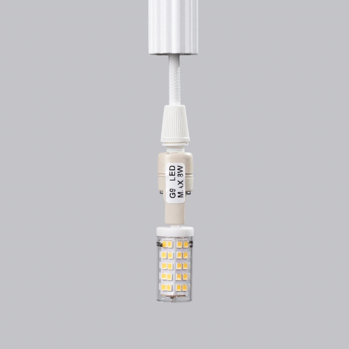 Pendelleuchte CORA 1 in Weiß – Detailaufnahme der G9-LED-Fassung mit eingesetztem LED-Leuchtmittel, textilummanteltes Kabel.