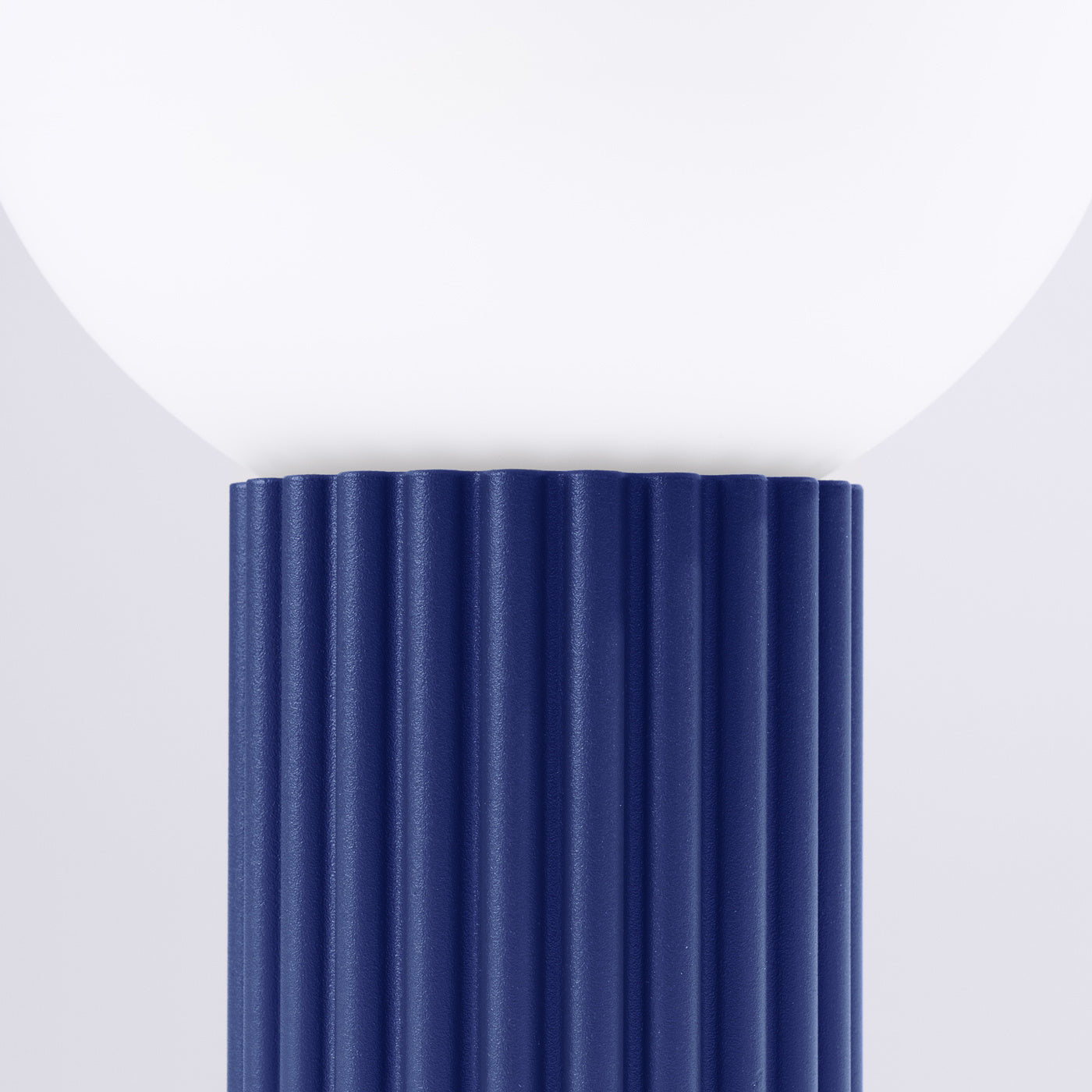 Detailansicht der HALO-Tischlampe in Ultramarinblau mit vertikal gerillter Struktur und Milchglasdiffusor.
