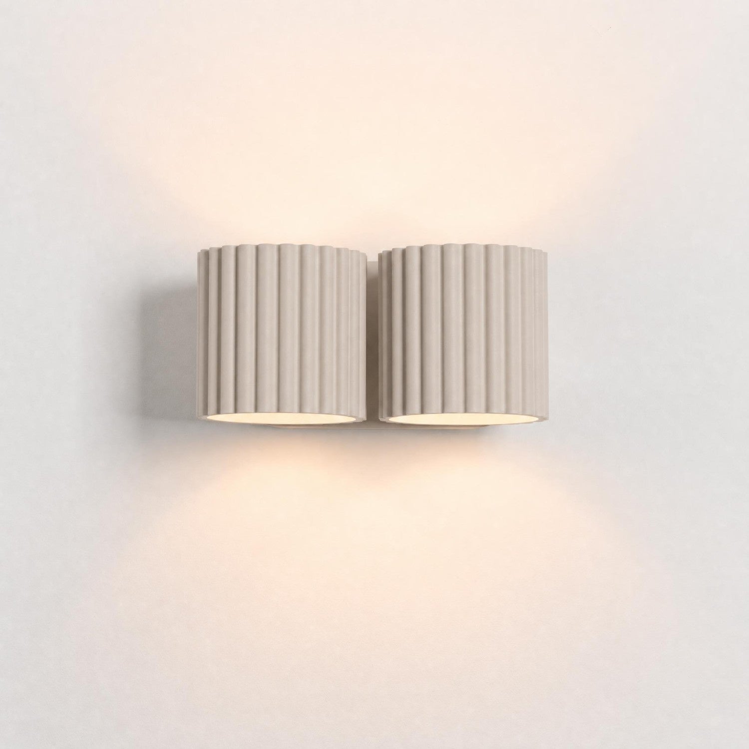 Wandleuchte AURA 2 in Taupe an der Wand – Licht nach oben und unten aus beiden Leuchtenkörpern | Dexity